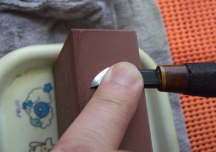 砥石の側面を使って、小刀の裏押しをしている画像です。